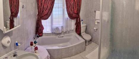 A bathroom with a bathtub, toilet, and sink.