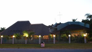 A hotel with a thatched roof and a separate building with a sign reading "LA ROCHELLE - INN". - La Rochelle Inn (Richards Bay)