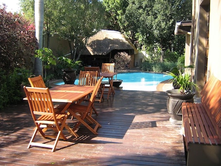 Una piscina al aire libre, sillones reclinables de piscina