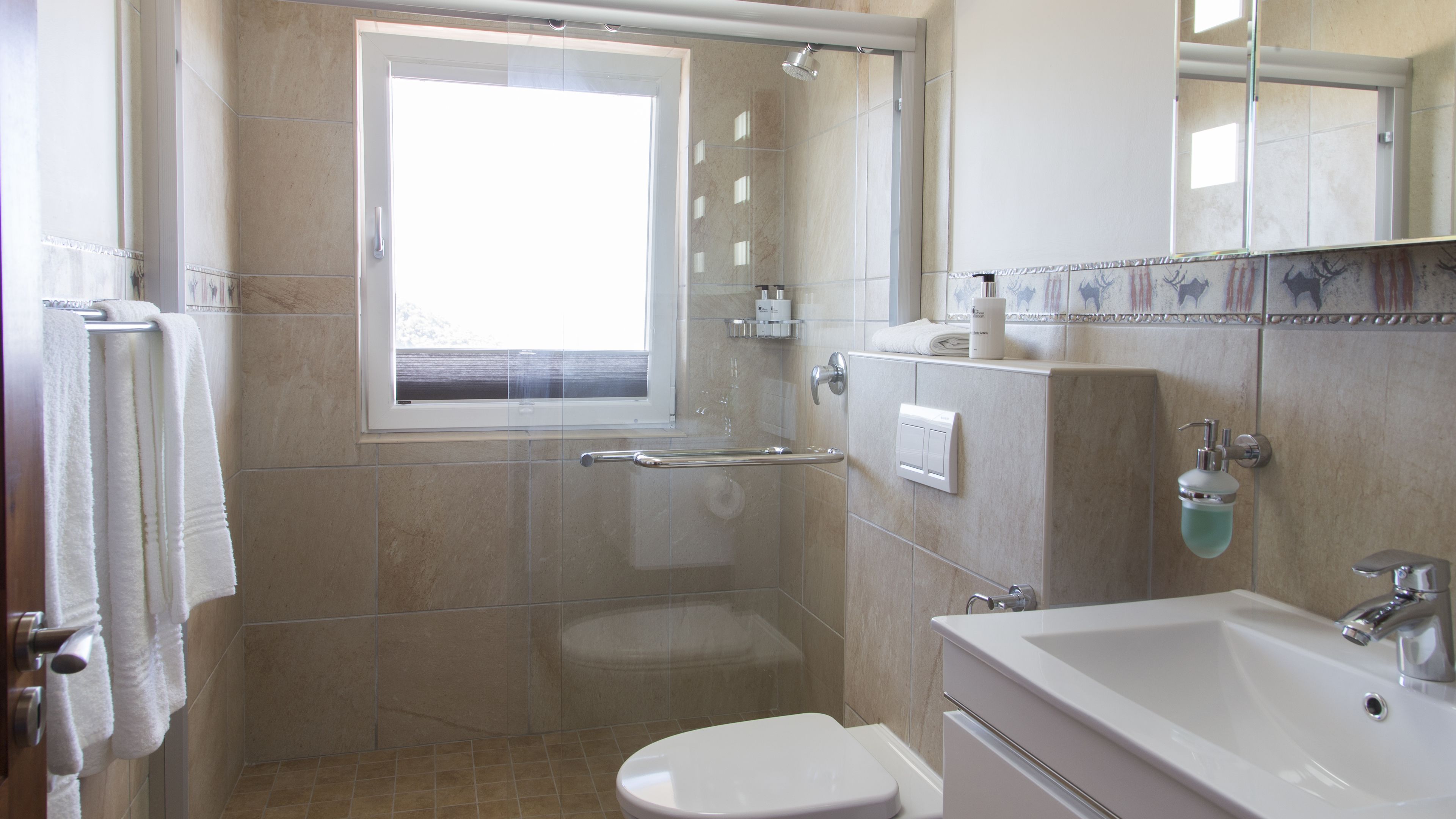 A bathroom with a shower, toilet, and sink.