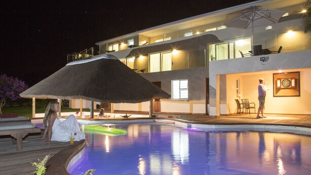 A modern house with a swimming pool, a covered patio, and a dartboard. - Lala Panzi B&B (Plettenberg Bay)