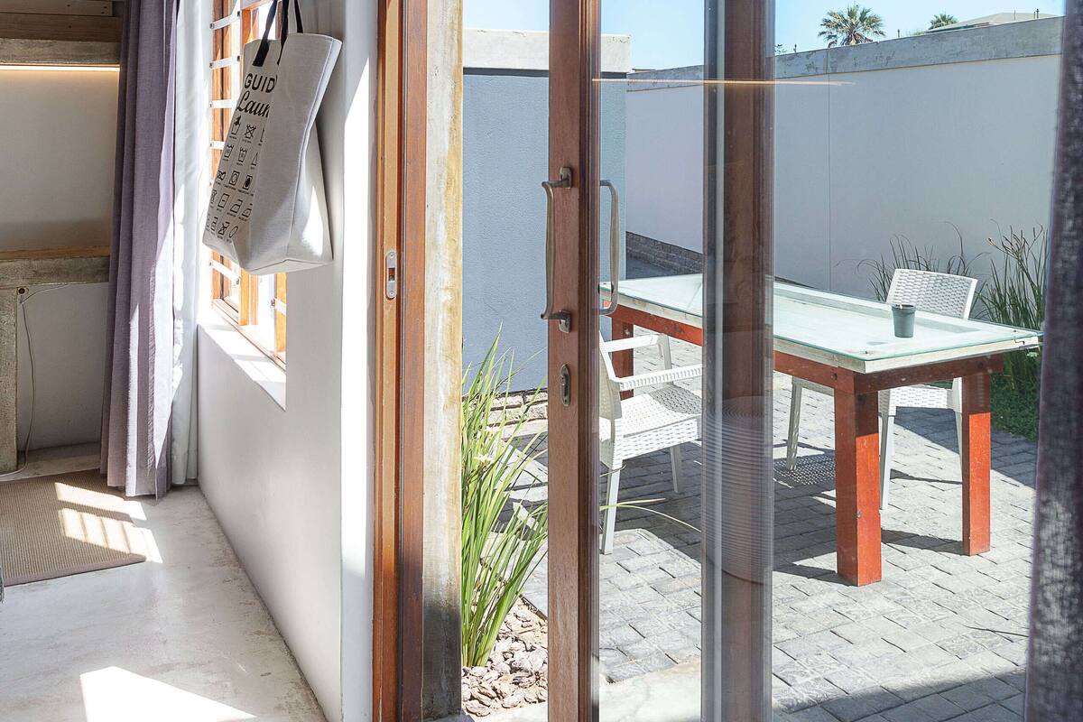Un intérieur moderne avec une porte-fenêtre coulissante donnant sur un patio extérieur.