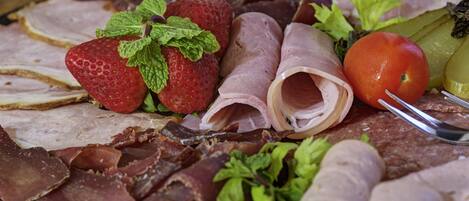 A variety of meats and fruits on a platter.