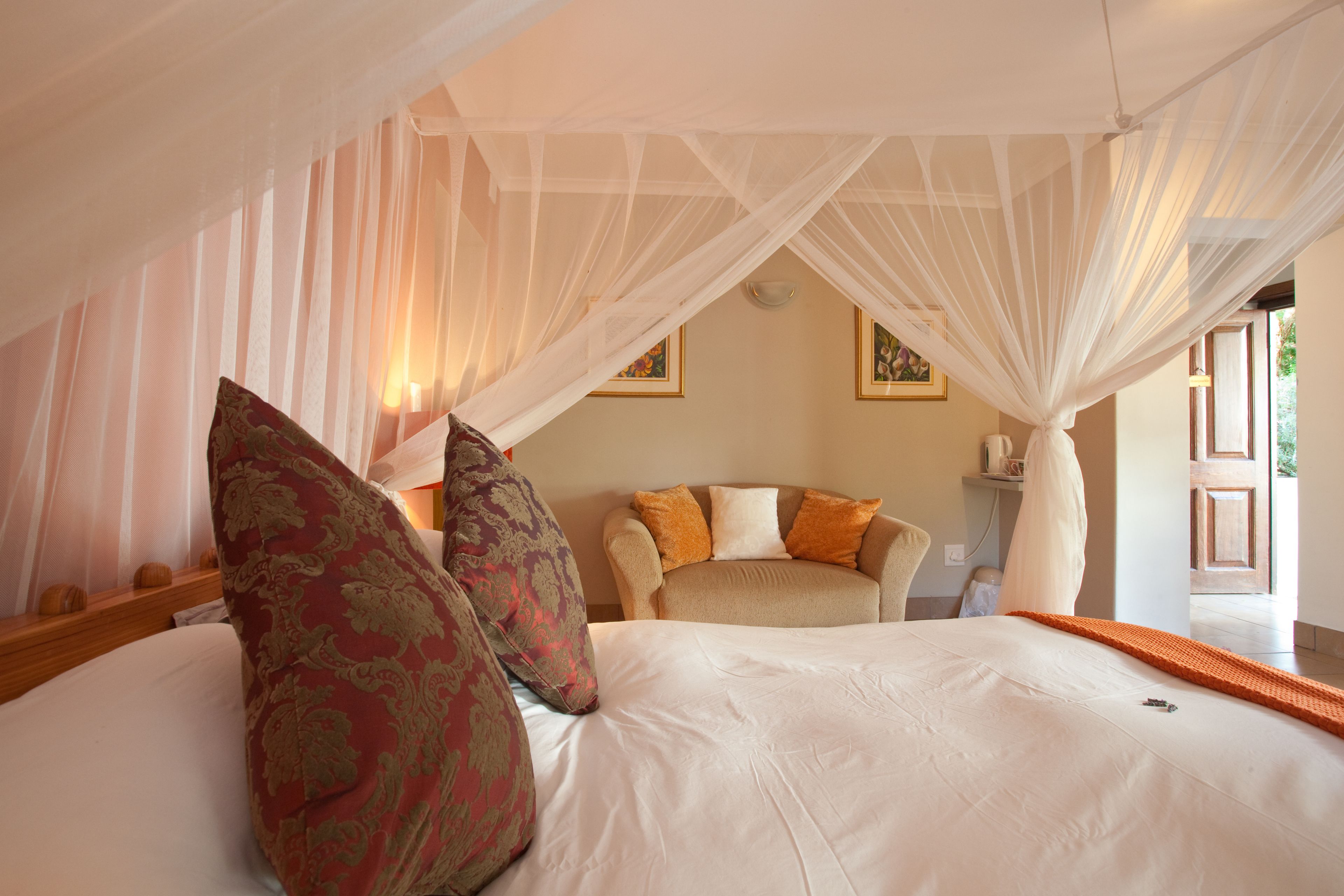 A bedroom with a bed, a nightstand, a bedside table, a lamp, and a window.