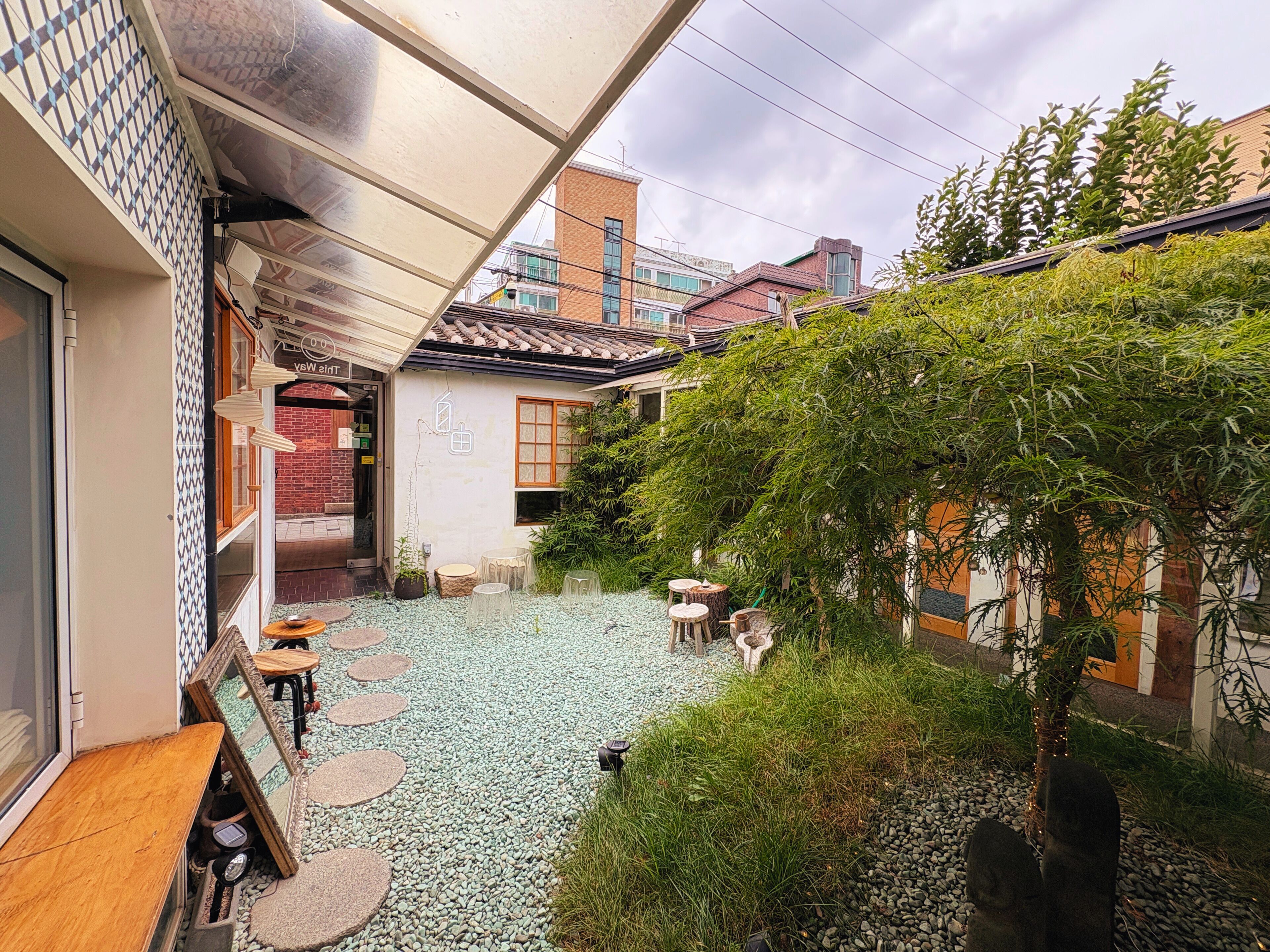 A courtyard with a tiled floor, outdoor seating, and a small tree.