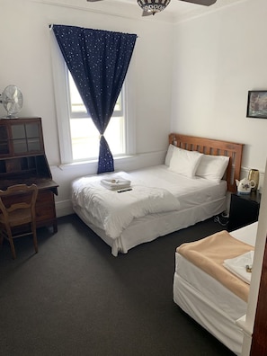 Quarto com uma cama, escrivaninha e cadeira.