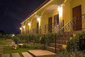 Un edificio con escaleras, una entrada bien iluminada y un jardín.