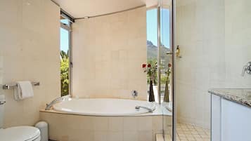 Luxe penthouse | Badkamer | Een aparte badkuip en douche, een haardroger, handdoeken, zeep