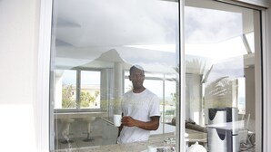 Eine moderne Küche mit großem Fenster, einer Arbeitsplatte und einem Spülbecken.