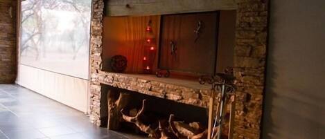 A stone fireplace with a built-in shelf and a decorative item on top.