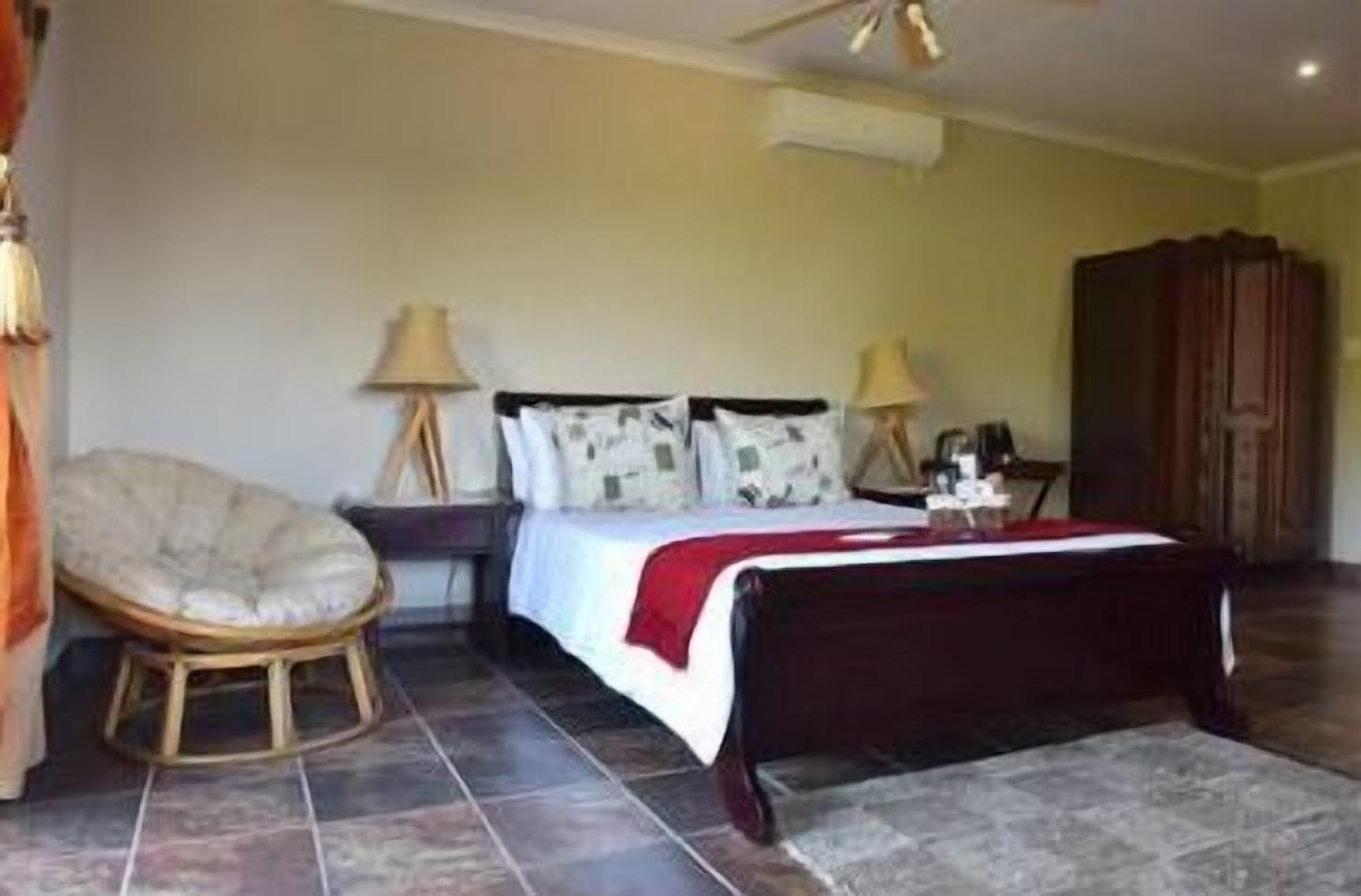 A bedroom with a bed, a chair, a nightstand, and a wardrobe.