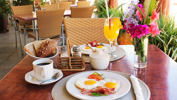 A breakfast table with eggs, toast, and a fruit salad. - Omaruru Guesthouse (Omaruru)