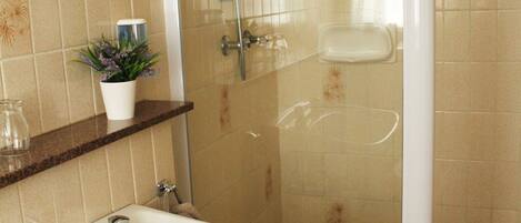 Un bagno con lavandino, specchio, doccia e piastrelle decorative.