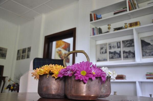 Three copper flower pots with handles on a table.