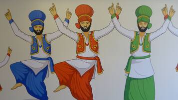 A mural of three individuals in traditional attire with raised hands.