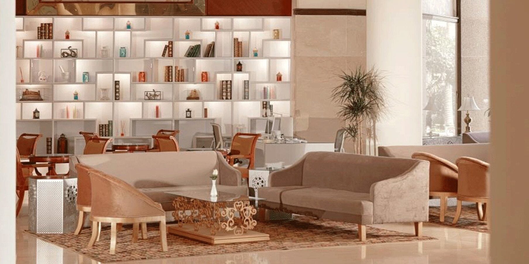 A modern living room with a sofa, chairs, a coffee table, and a bookshelf filled with various items.