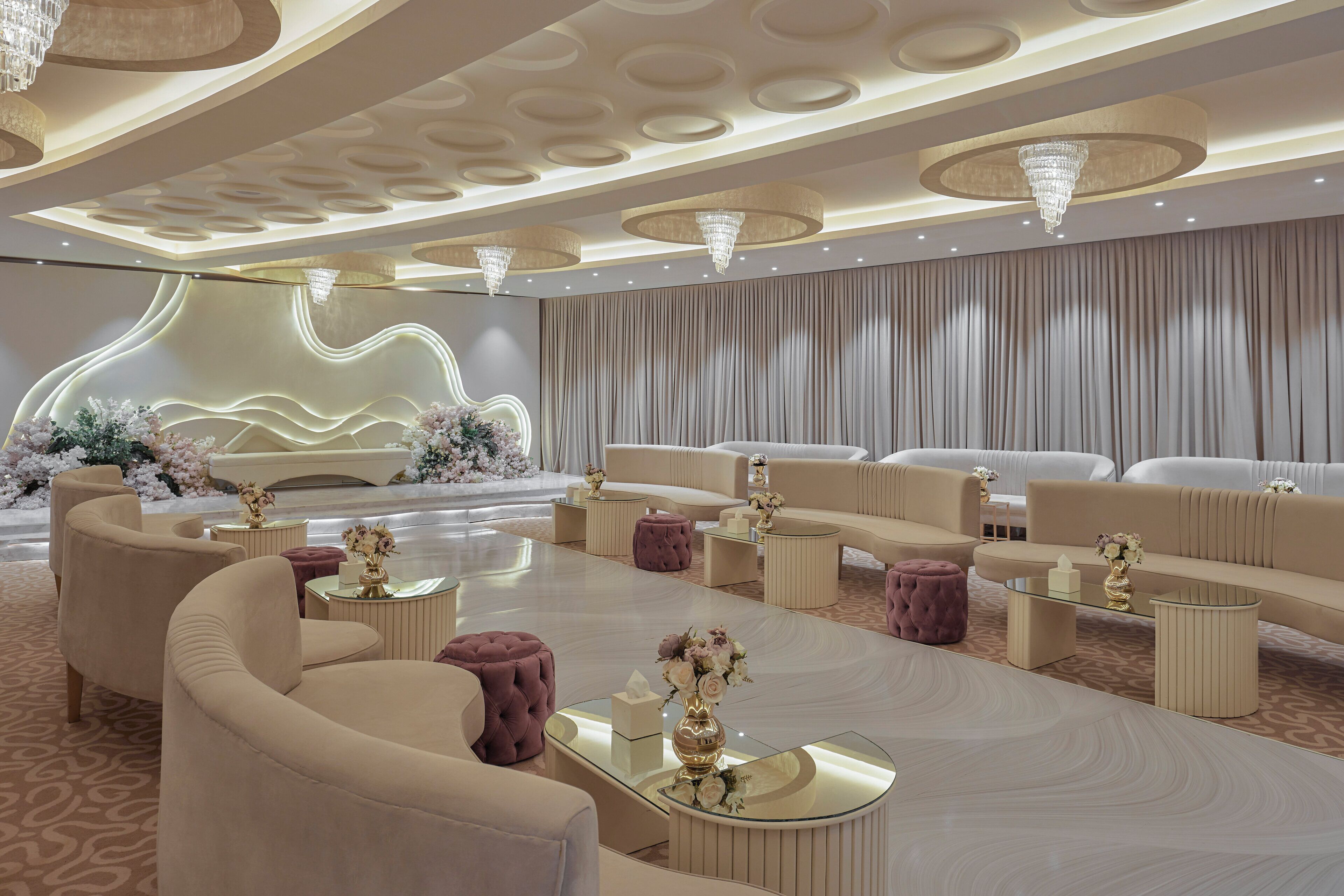 A modern hotel lobby with plush seating, decorative vases, and a patterned carpet.