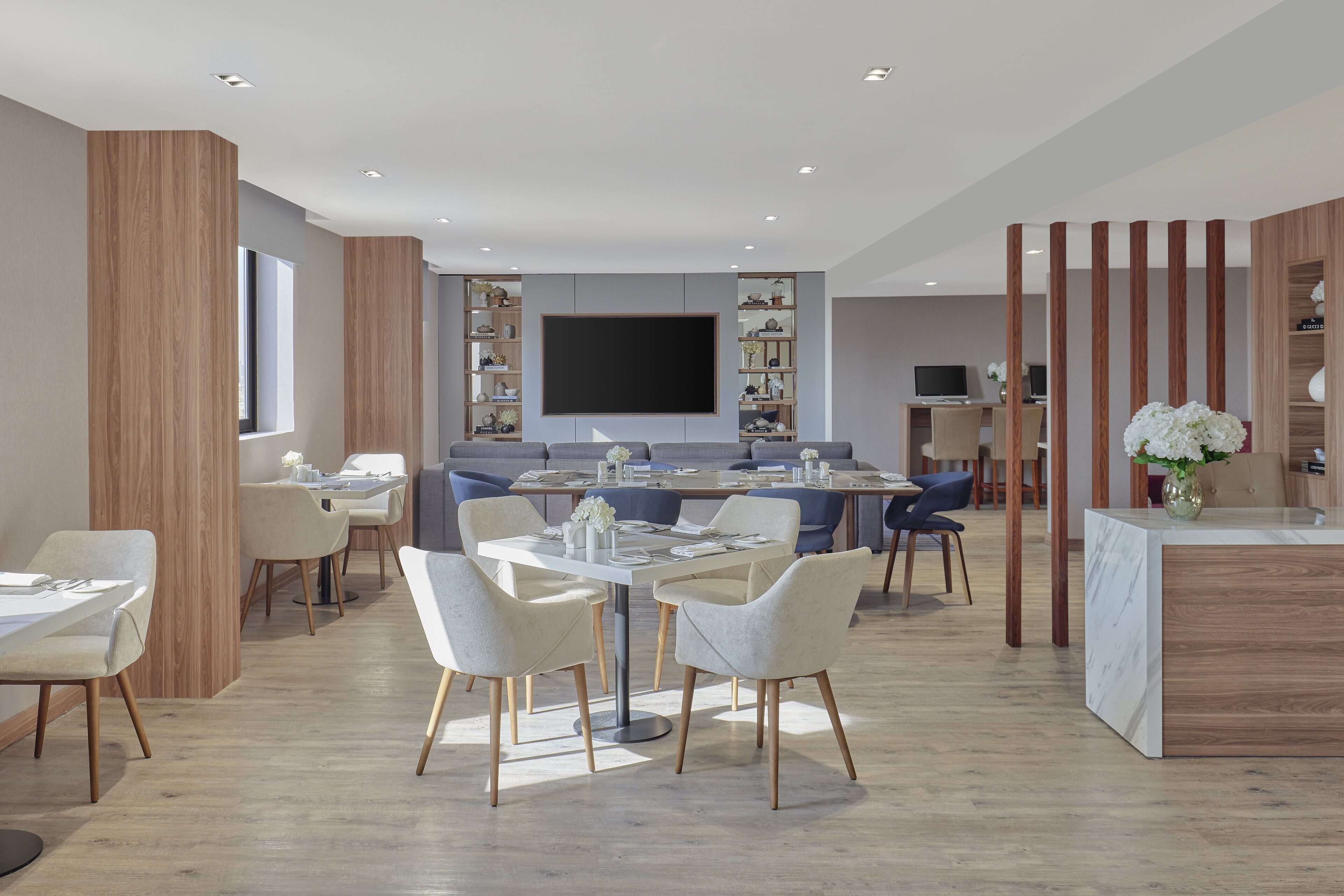 Un comedor moderno con una mesa central, sillas y una pantalla de televisión.