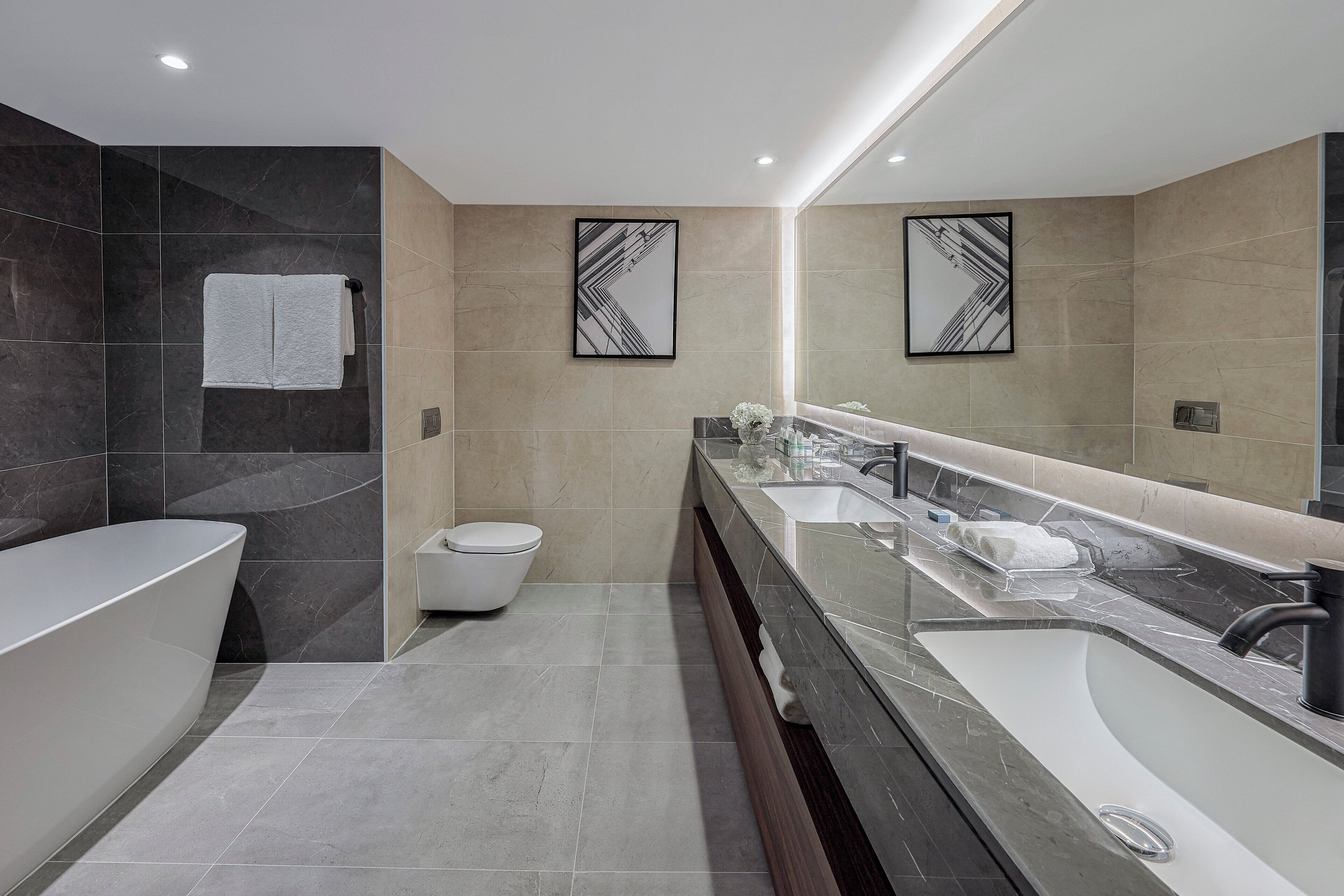 A modern bathroom with a bathtub, a toilet, and a vanity with a sink.