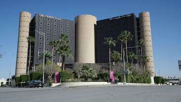 Un edificio moderno con una torre cilíndrica central, varios pisos y un techo plano.