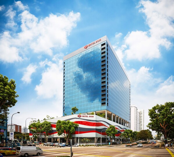 A modern hotel with a glass facade and a prominent 'HOTEL BOSS' sign.