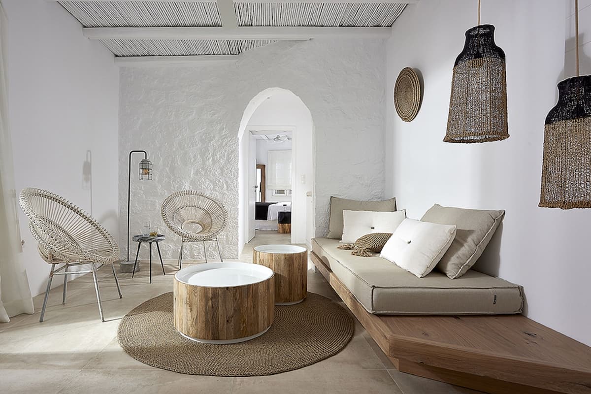 A modern living room with a sofa, two chairs, a coffee table, and a woven rug.