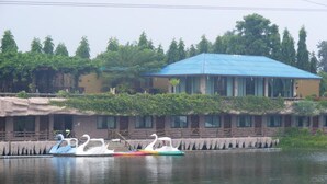 A building with a blue roof and a row of windows. - Chart Thip Resort (Sung Noen)