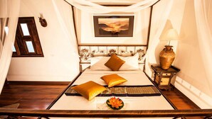 A bed with a headboard, a bedside table with a lamp, and a picture on the wall. - Chart Thip Resort (Sung Noen)