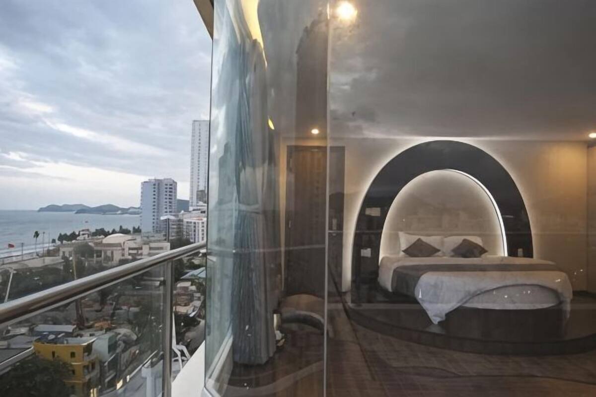 A bedroom with a curved ceiling, a bed, and a view of the city.