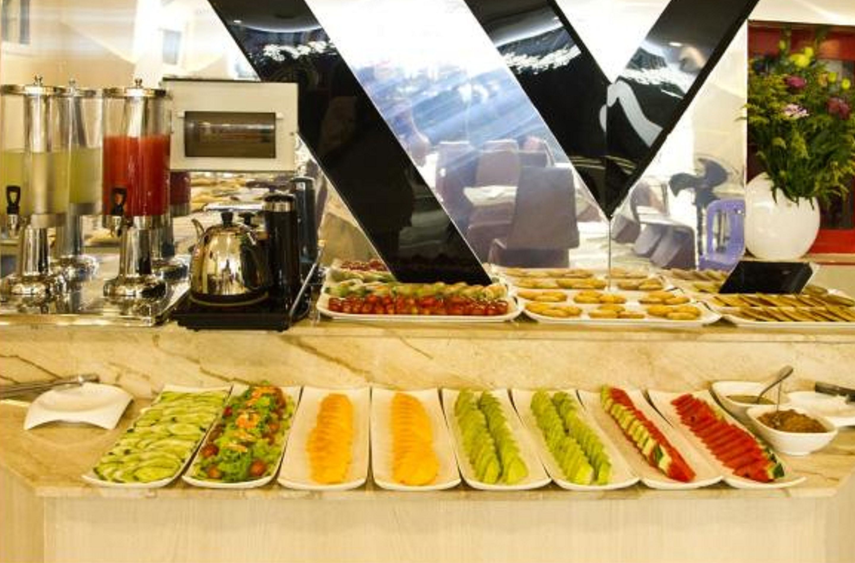 A buffet with various food items and a coffee station.