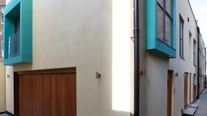 Un bâtiment moderne à la façade plate, doté de grandes fenêtres et d’une porte de garage en bois.