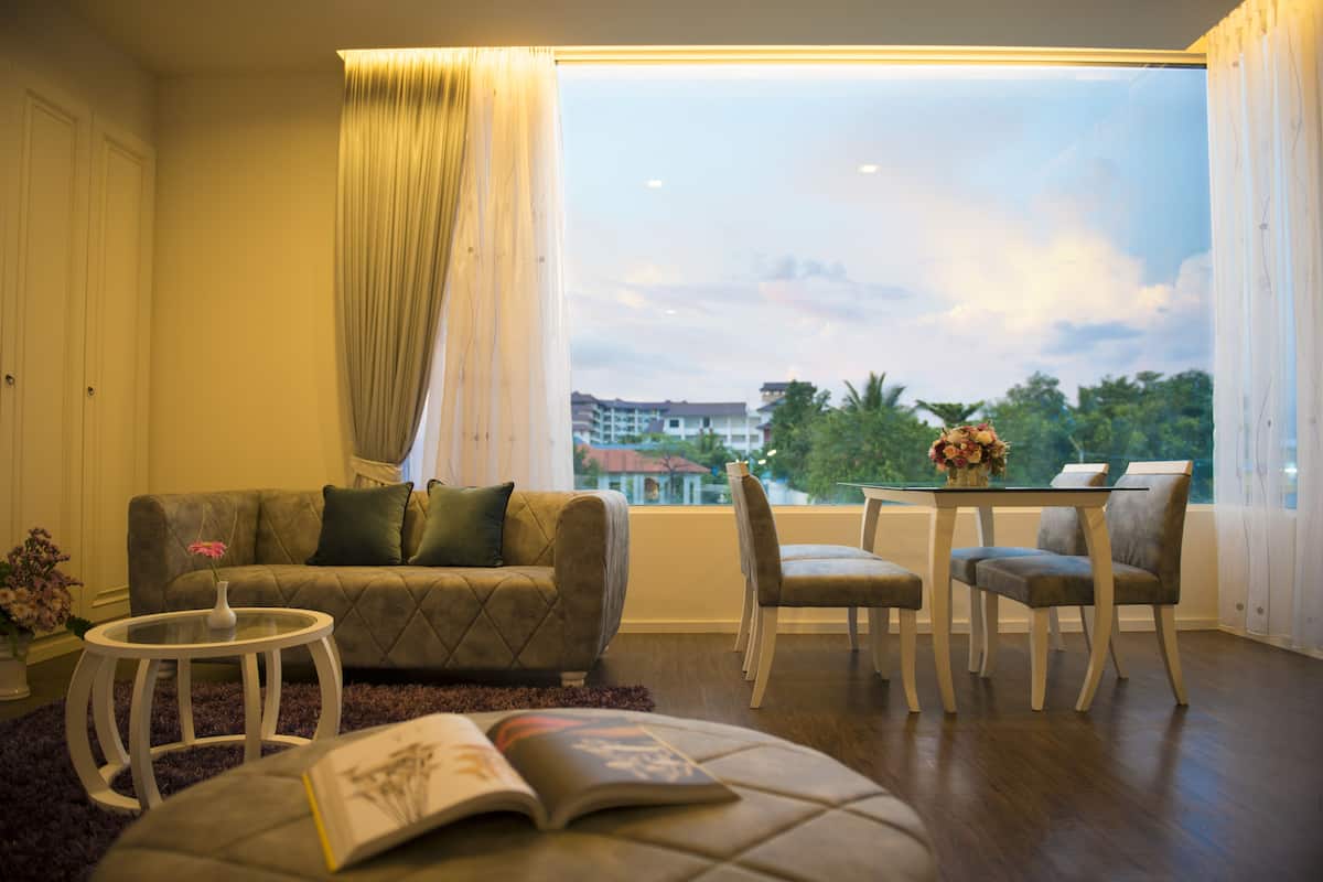 A living room with a sofa, a small table, and a dining area with chairs.