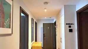 A hallway with wooden flooring, a bench, and a door marked with the number 6.