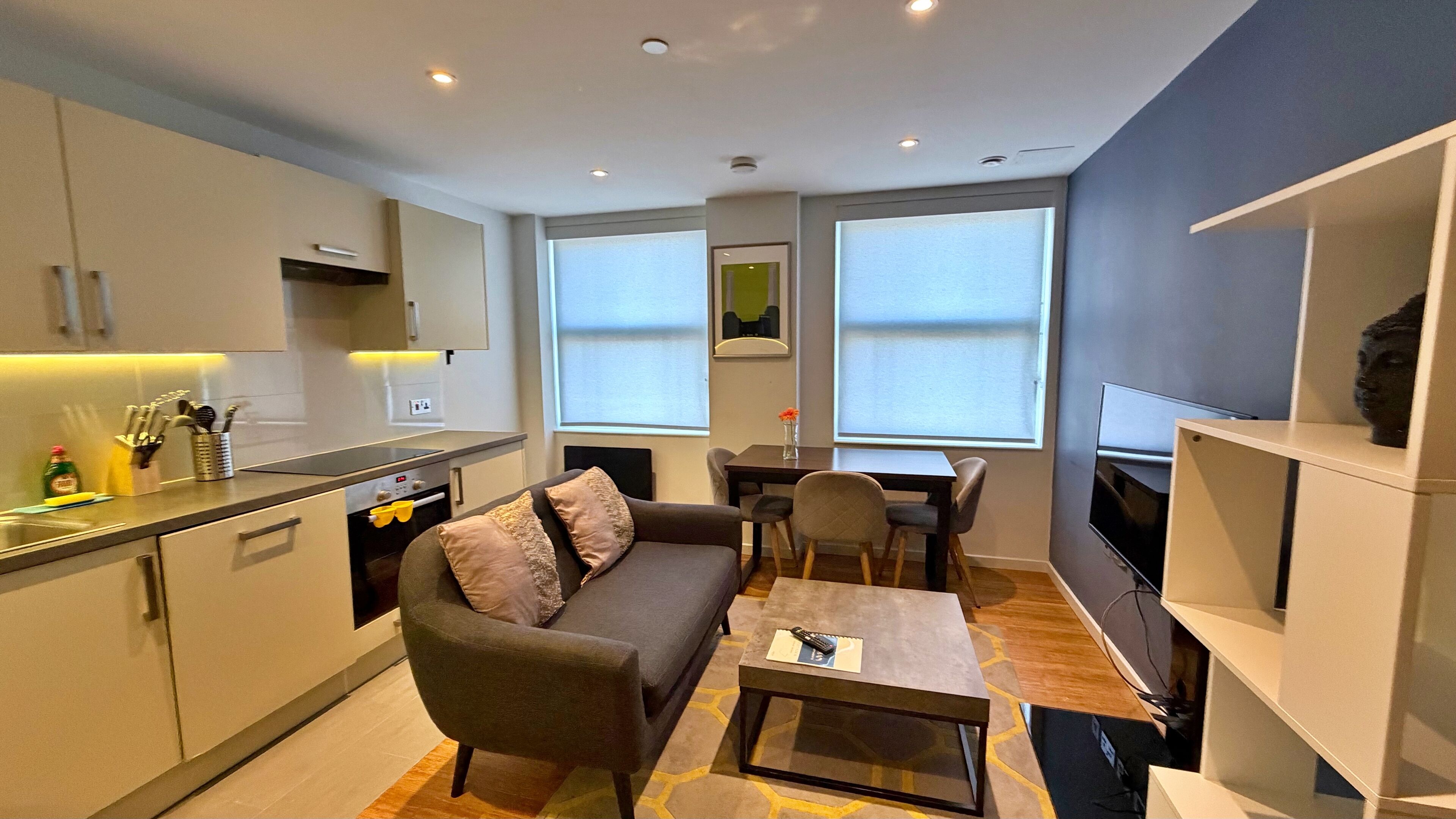 A compact living space with a kitchenette, a sofa, a coffee table, and a TV.