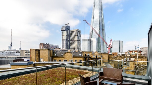 A rooftop terrace with a view of the Shard and surrounding buildings. - London Bridge – Tooley St by Viridian Apartments (London)
