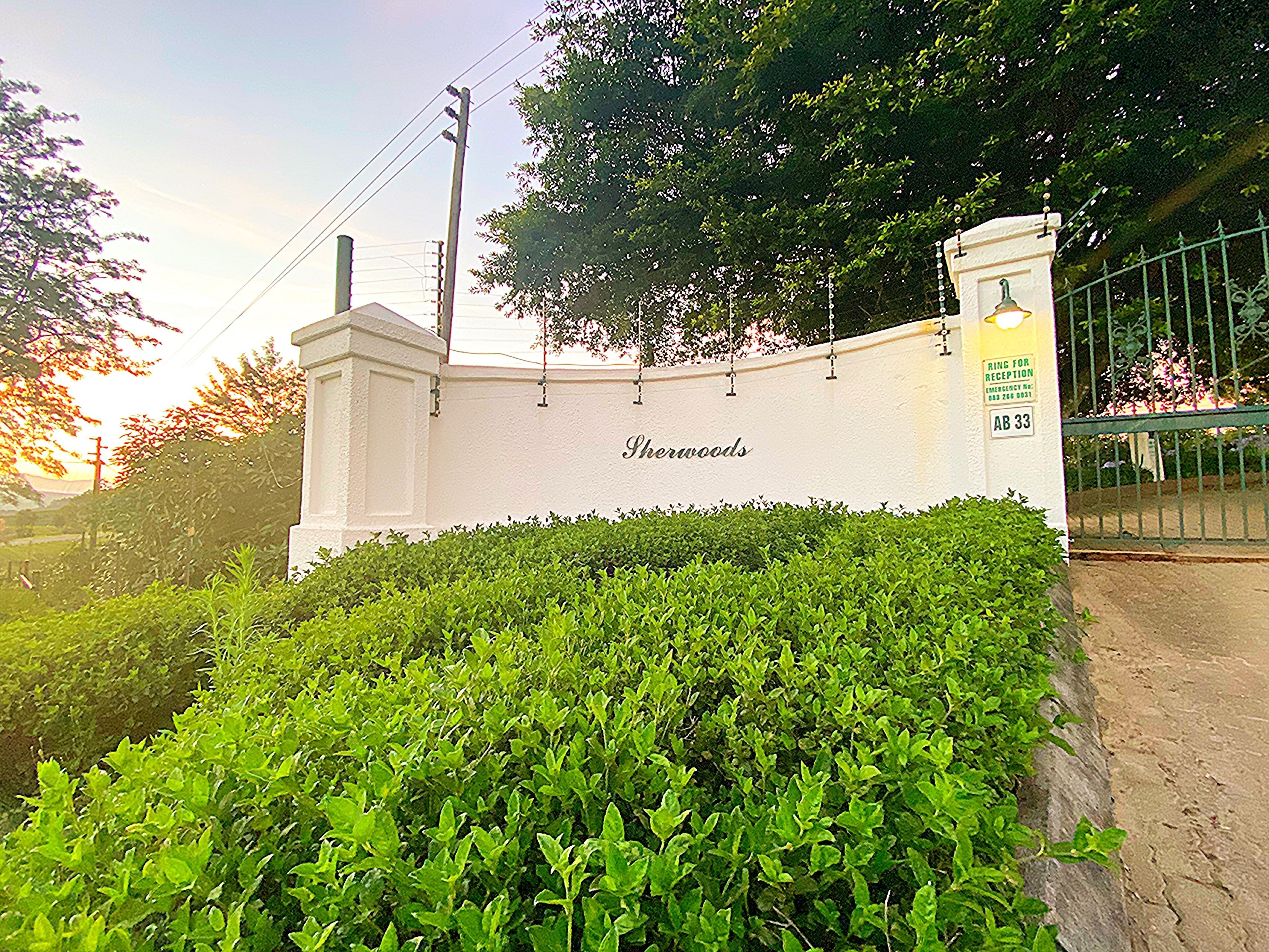 A white wall with the name 'Sherwoods' and a reception sign.