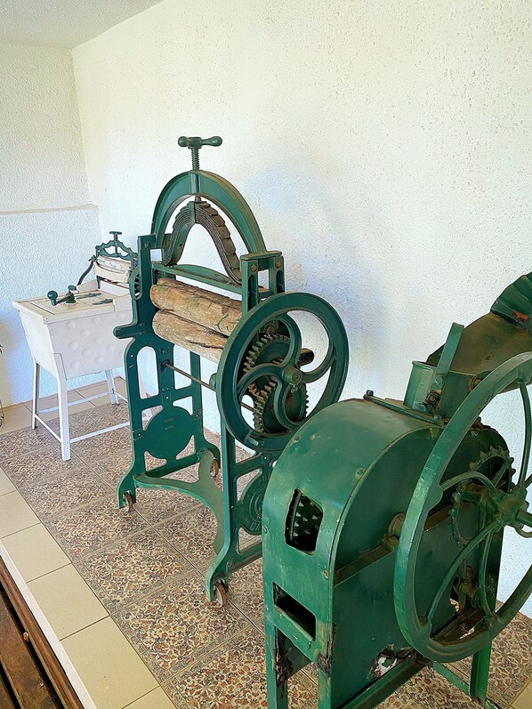 Antique green machinery with wheels and gears, likely from a historical exhibit.