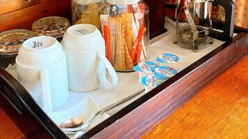 A wooden tray with various breakfast items including coffee, tea, and condiments.