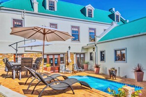 Piscine extérieure, parasols de plage, chaises longues