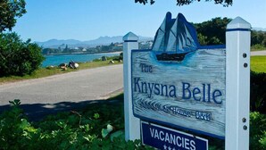A sign for The Kynsna Belle, a guesthouse with a scenic view of a lake and mountains. - The Knysna Belle (Knysna)