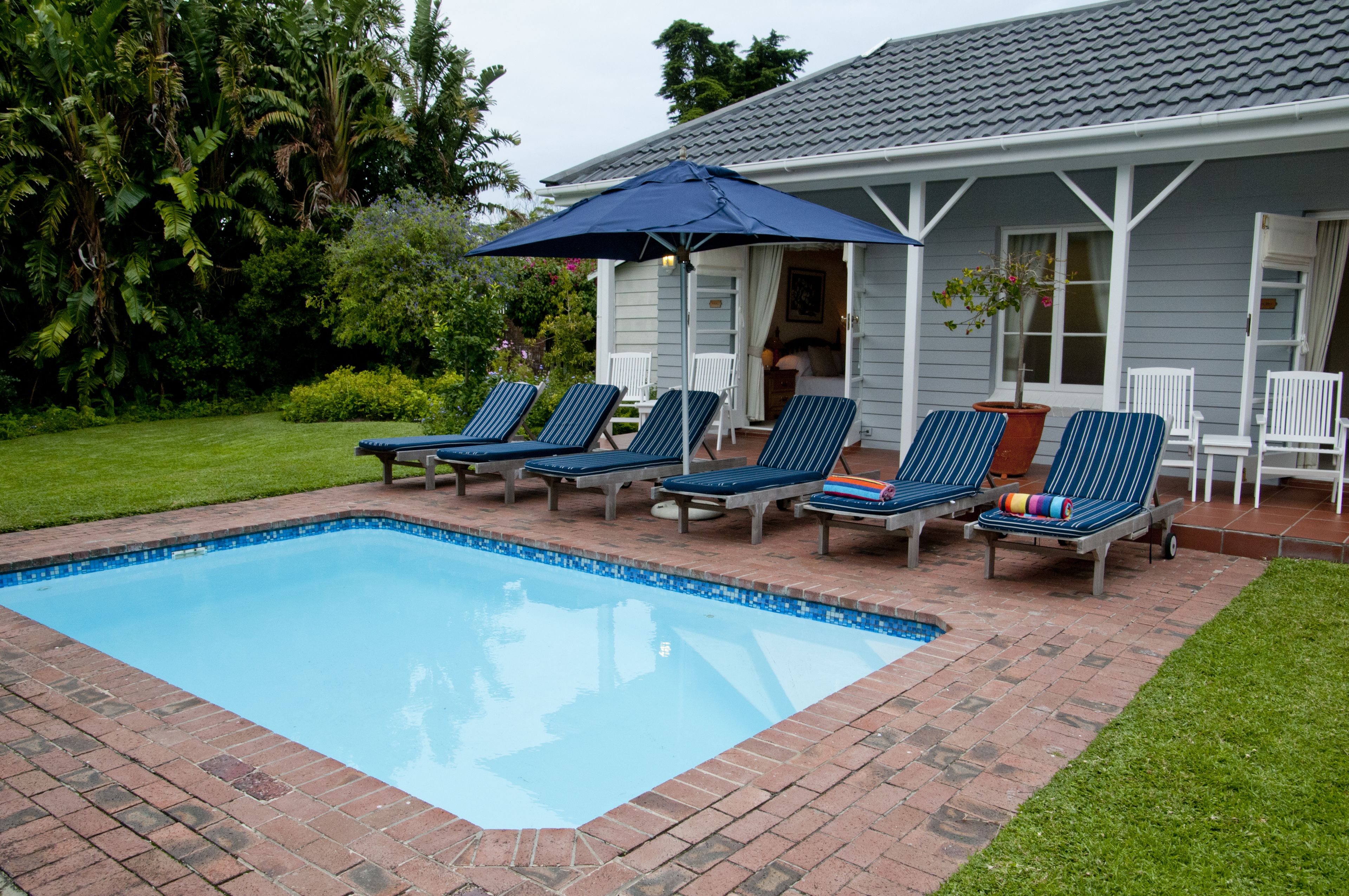 حمّام سباحة خارجي موسمي، مظلات على حمّام السباحة، مقاعد للتشمس