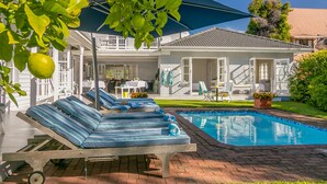 A poolside area with lounge chairs and a swimming pool. - The Knysna Belle (Knysna)