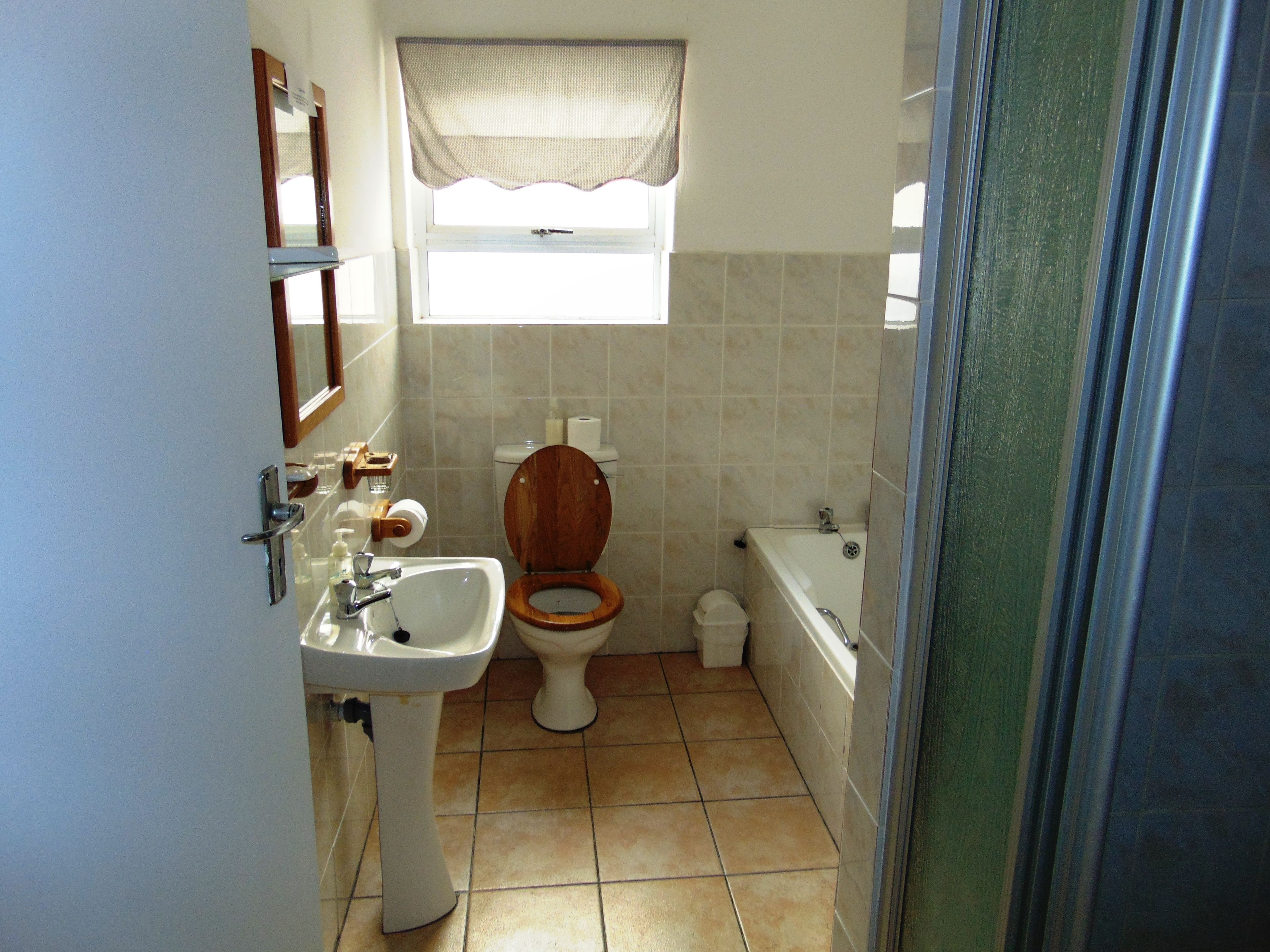 Un bagno con servizi igienici in legno, un lavandino e una vasca da bagno.