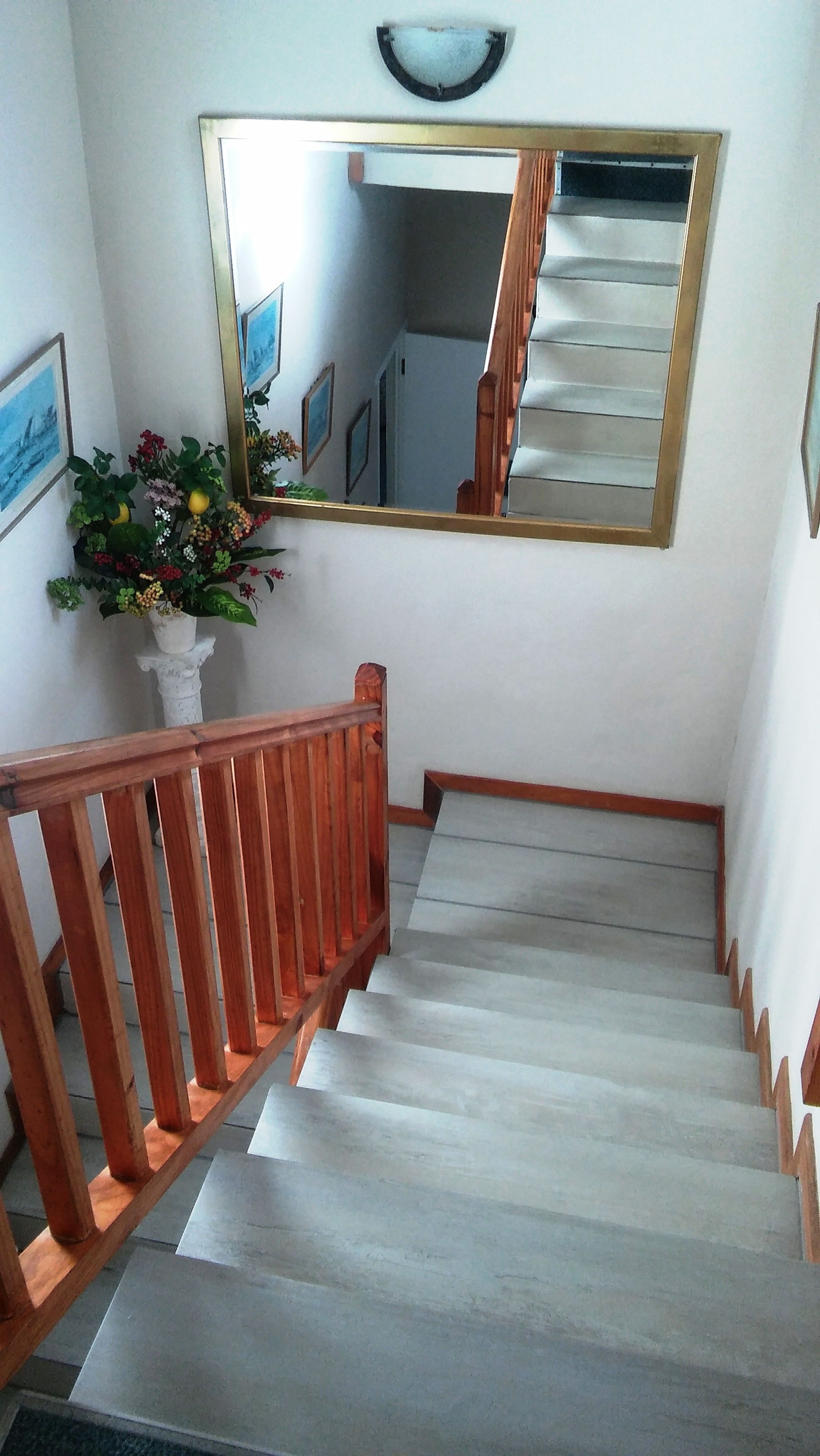 Un escalier avec des rampes en bois et un mur blanc.