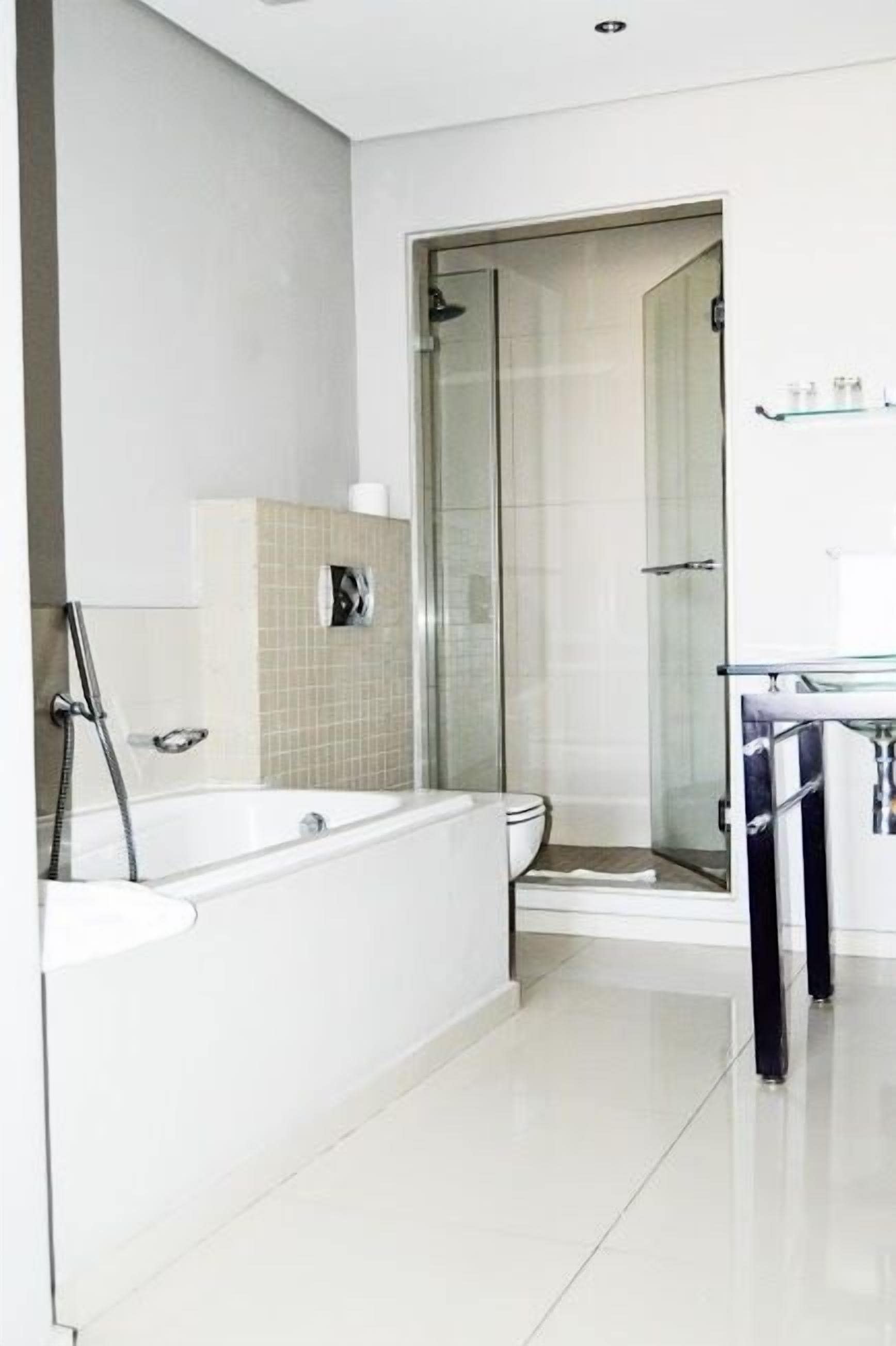 Un baño moderno con bañera, ducha y cabina de ducha acristalada.