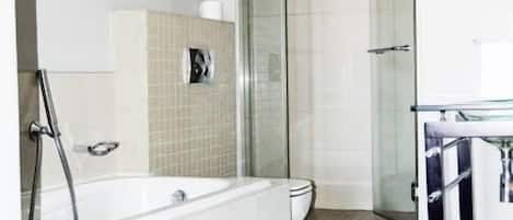 Un baño moderno con bañera, ducha y cabina de ducha acristalada.