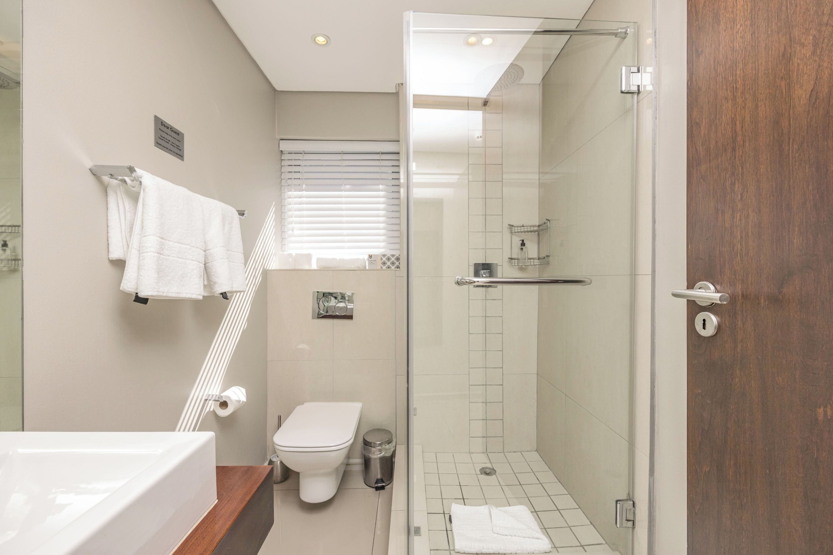 A bathroom with a shower, toilet, and sink.