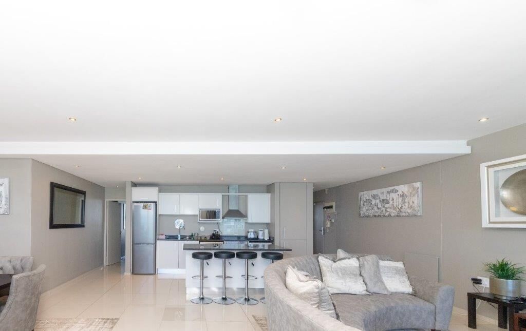 A modern apartment with a kitchen, dining area, and living room.