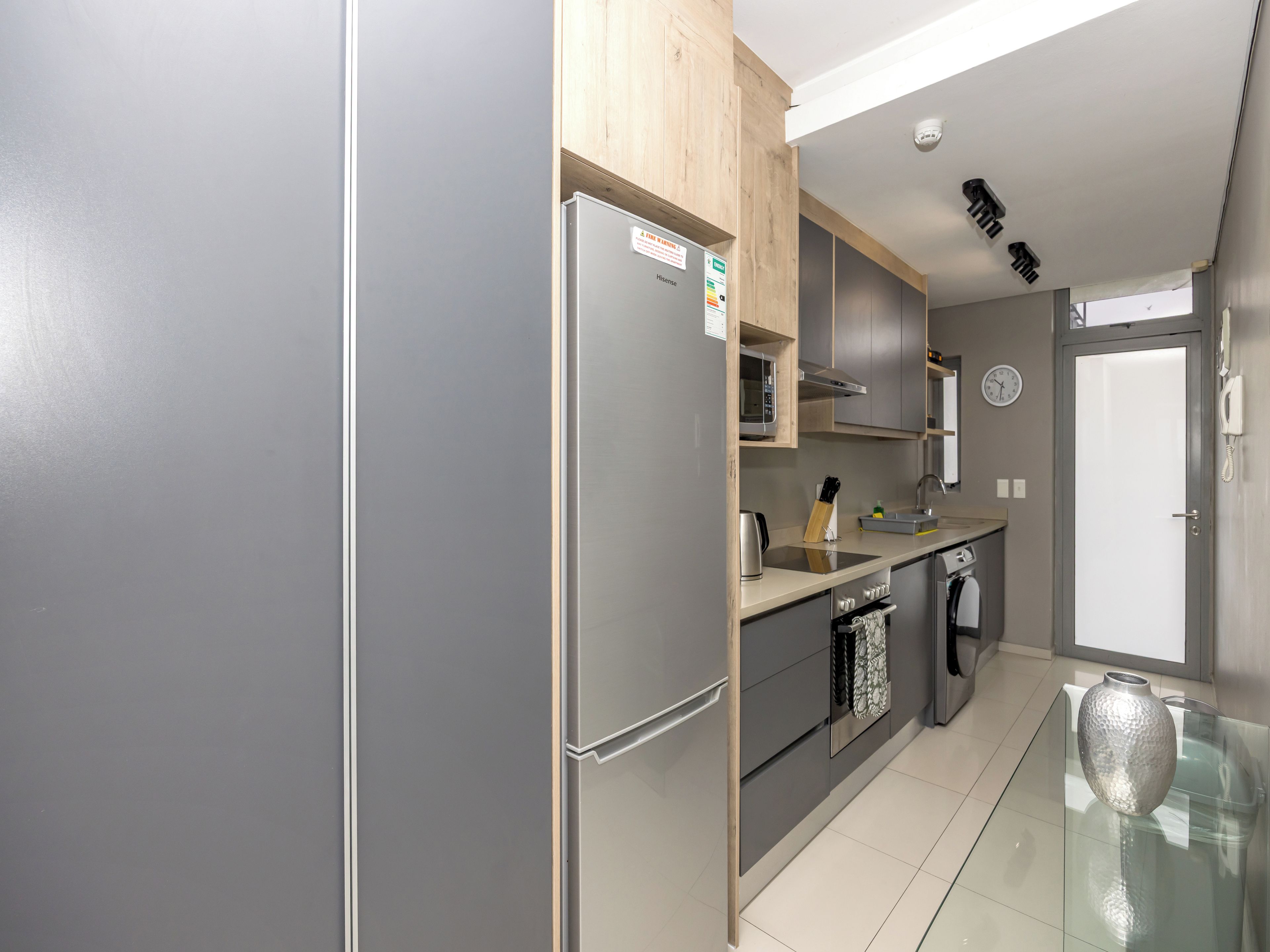 A modern kitchen with a refrigerator, stove, microwave, and sink.