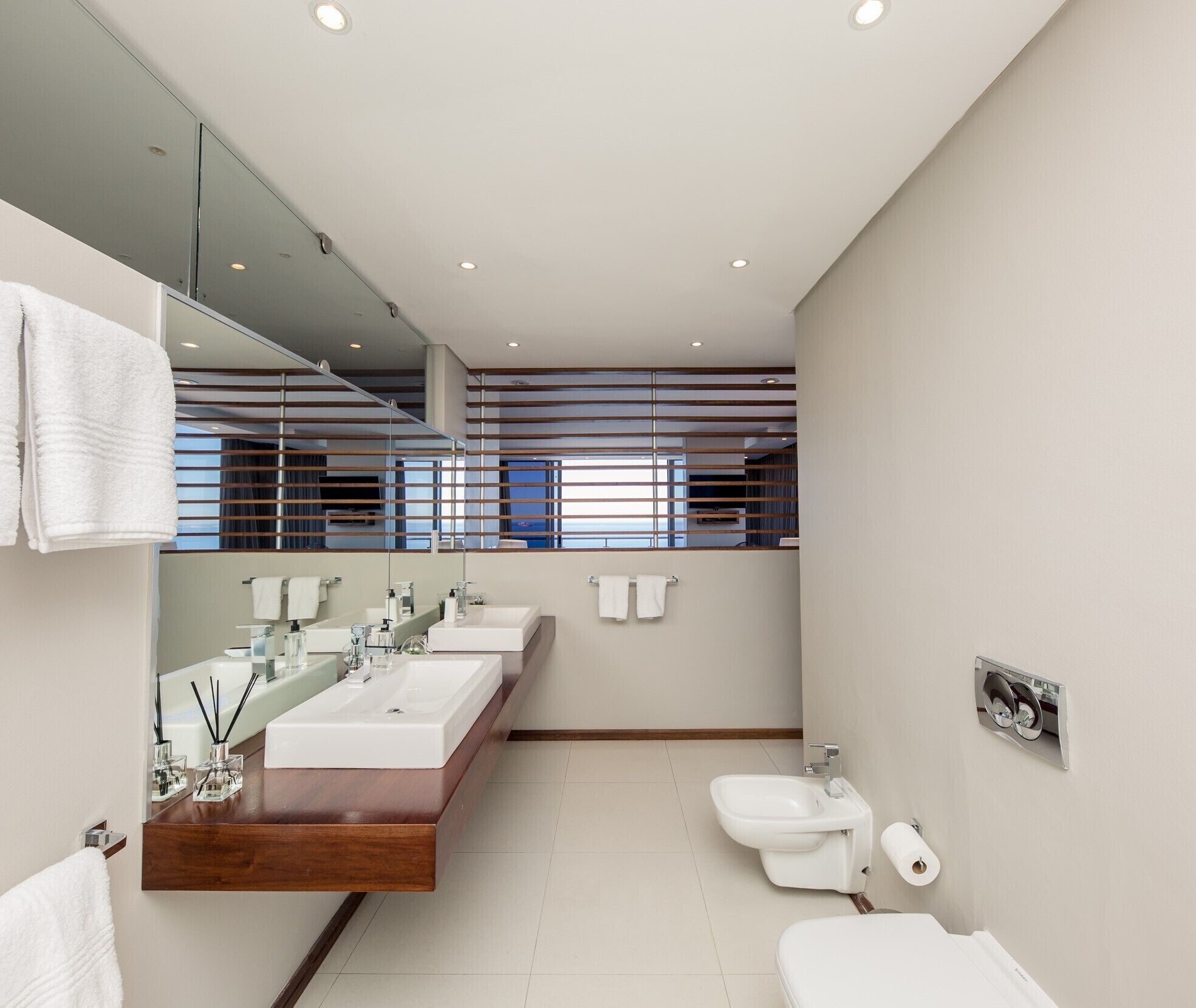 A modern bathroom with two sinks, a bidet, and a toilet.